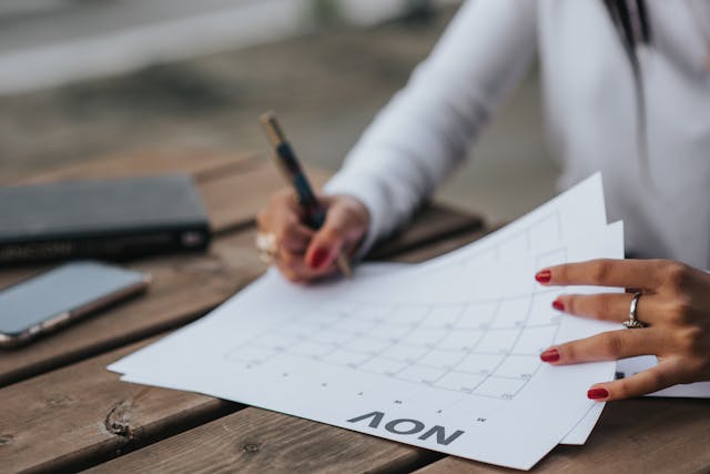 someone writing on a large calendar