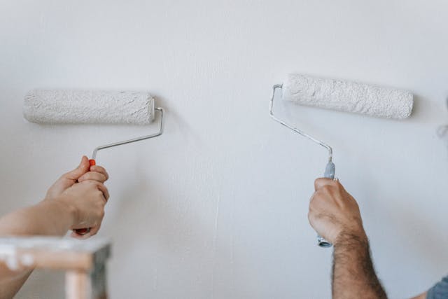 two paint rollers on a white wall