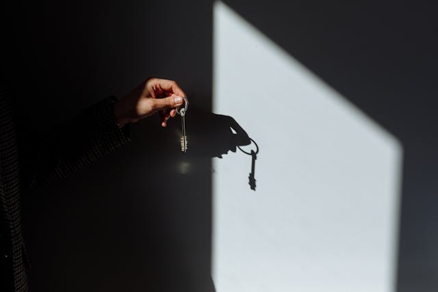 a hand holding up a pair of keys